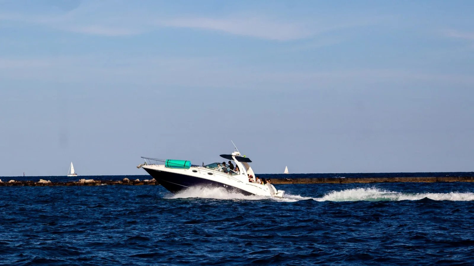 White motorboat speeding across deep blue water